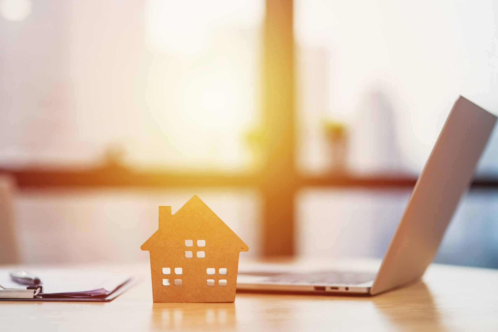 Home model put near Lease or Rental agreement document and laptop with copy space, real estate Business for buy , loan or investment concept