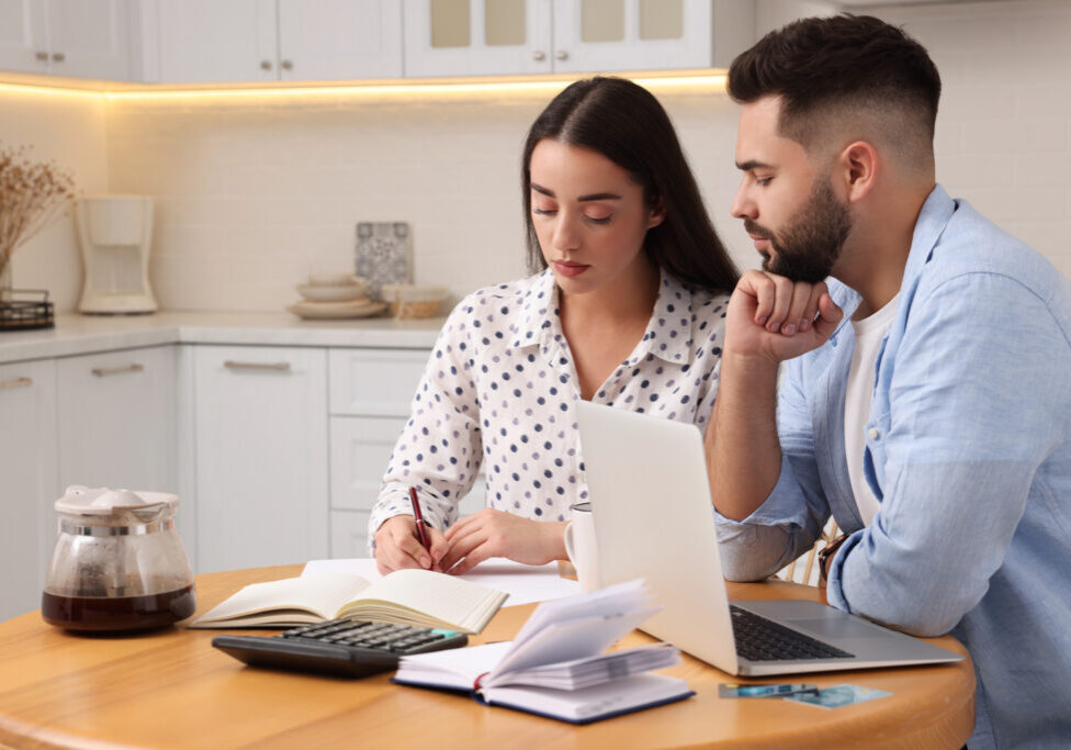 Young couple discussing family budget in kitchen