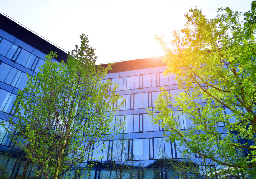 Reflection of modern commercial building on glass with sunlight.