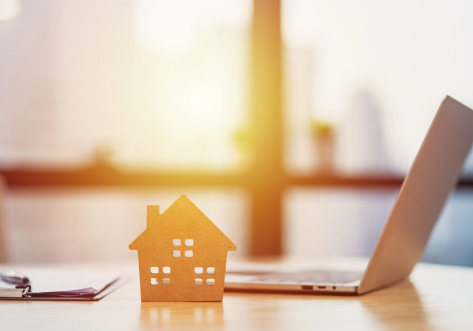 Home model put near Lease or Rental agreement document and laptop with copy space, real estate Business for buy , loan or investment concept